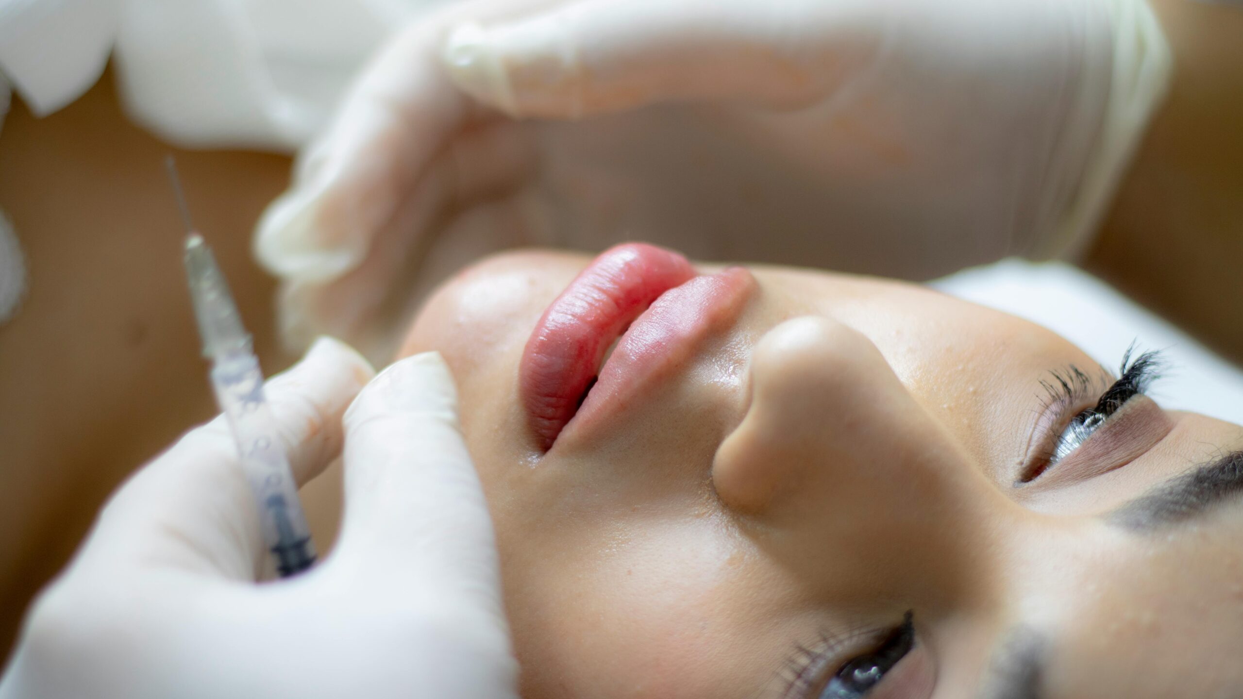 Aesthetic doctor administering dermal filler to the mid-face area for facial contouring and volume restoration.